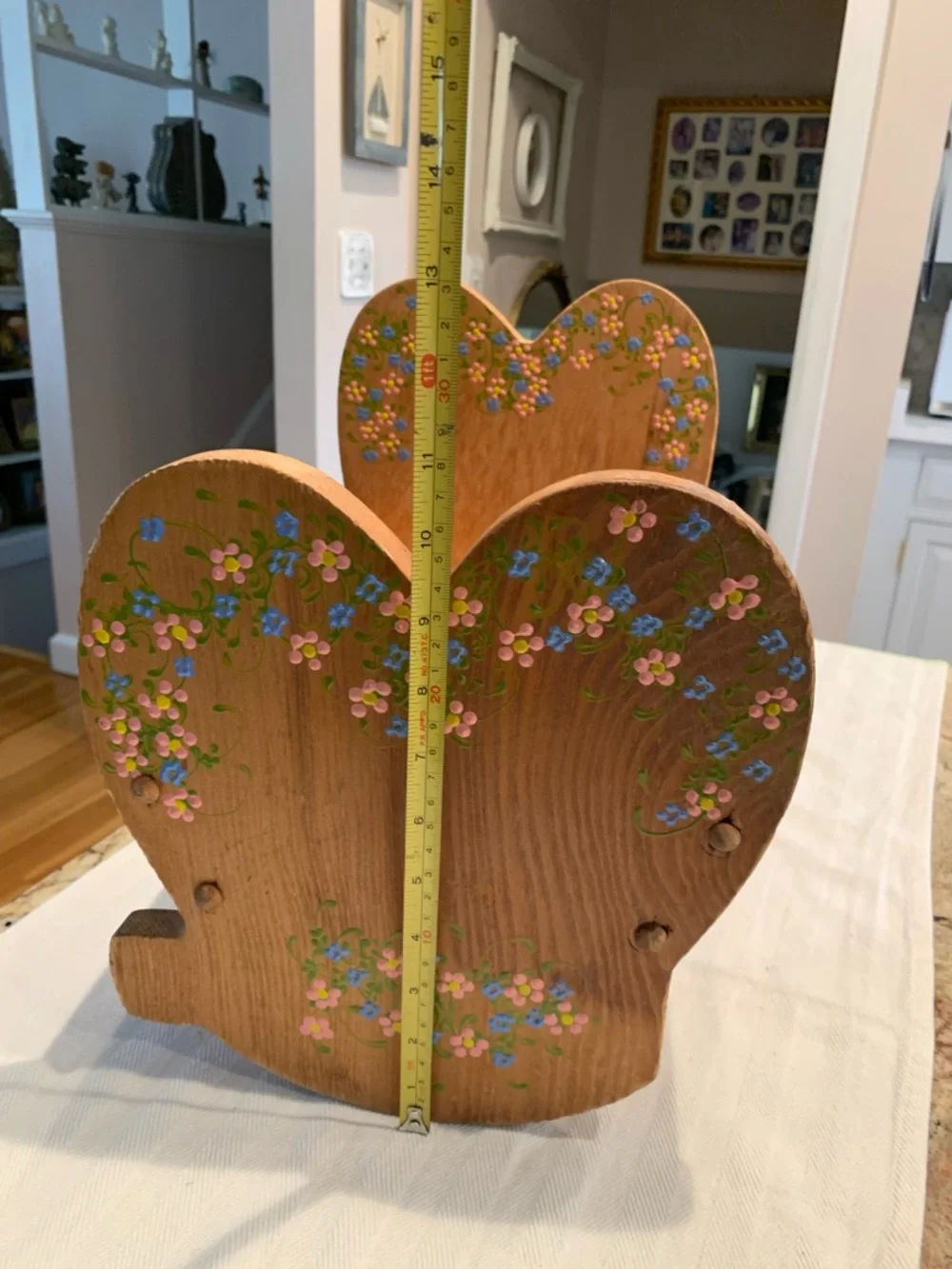 Vintage wooden doll cradle heart-shaped design painted with floral details.